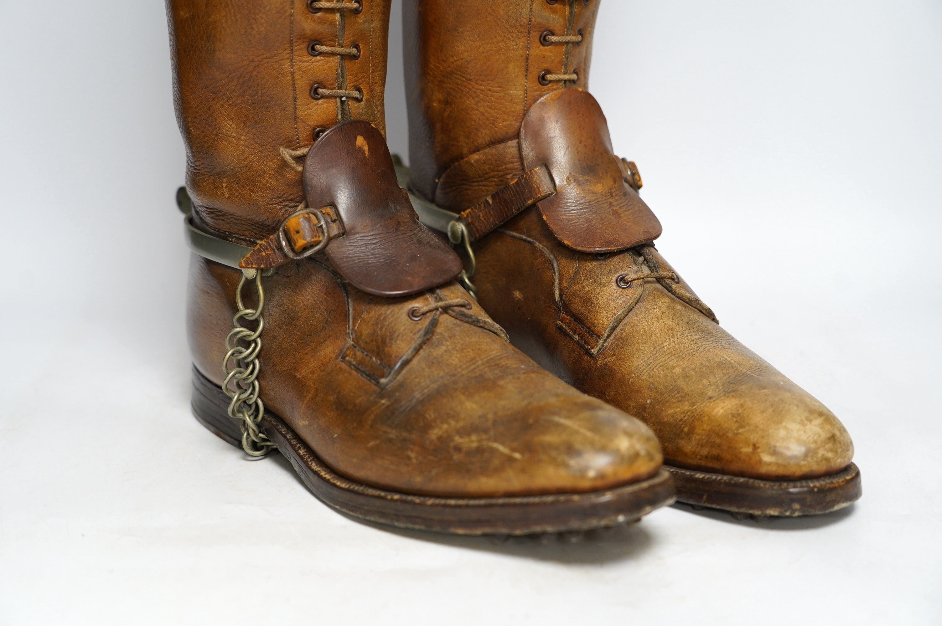 A pair of military First World War boots in tan leather, hobnail soles, two-part wooden shoe trees, and spurs. Condition - fair to good, some rubbing, fading and staining to the leather
